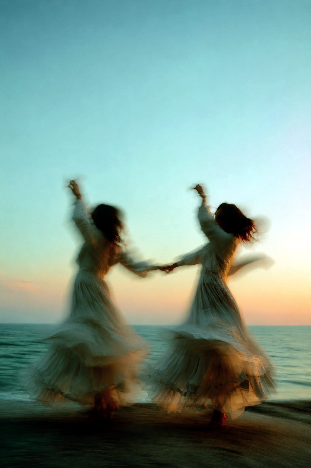 Two women dancing at sunset